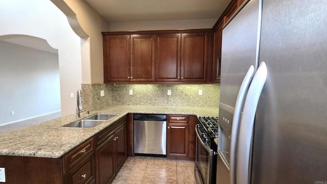 4148 Karst Rd, Carlsbad, CA 92010 - kitchen featuring appliances with stainless steel finishes, a peninsula, backsplash, light stone counters, and light tile patterned flooring