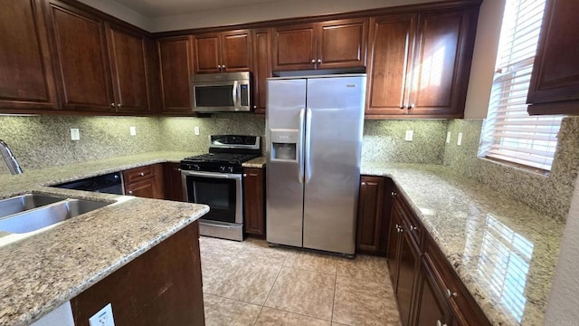 4148 Karst Rd, Carlsbad, CA 92010 - kitchen featuring appliances with stainless steel finishes, backsplash, light stone counters, and light tile patterned floors