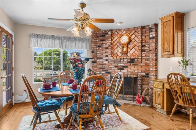 530 Bradbury Rd, Monrovia, CA 91016 - dining space with light wood-style flooring, healthy amount of natural light, ceiling fan, and a brick fireplace