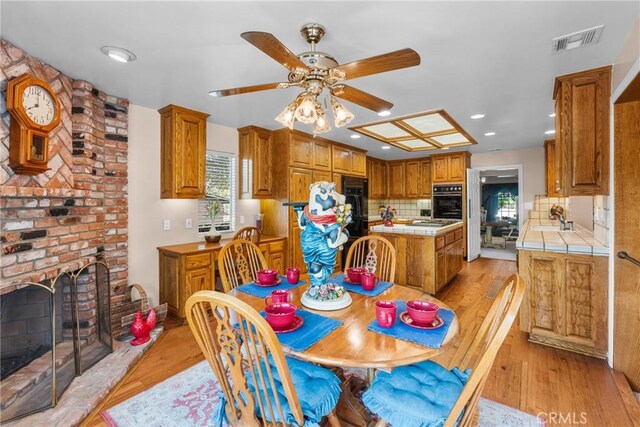 530 Bradbury Rd, Monrovia, CA 91016 - dining space with a ceiling fan, light wood-type flooring, recessed lighting, and a brick fireplace