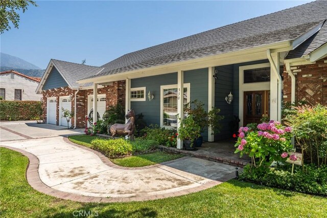 530 Bradbury Rd, Monrovia, CA 91016 - view of front facade with driveway, an attached garage, a porch, and brick siding