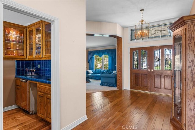530 Bradbury Rd, Monrovia, CA 91016 - foyer entrance with a chandelier, bar with sink, and light wood-type flooring