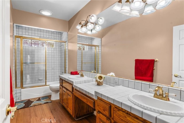530 Bradbury Rd, Monrovia, CA 91016 - bathroom featuring double vanity, wood finished floors, bath / shower combo with glass door, and a chandelier