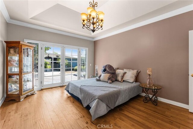 530 Bradbury Rd, Monrovia, CA 91016 - bedroom with access to exterior, a chandelier, light wood-style floors, a raised ceiling, and crown molding