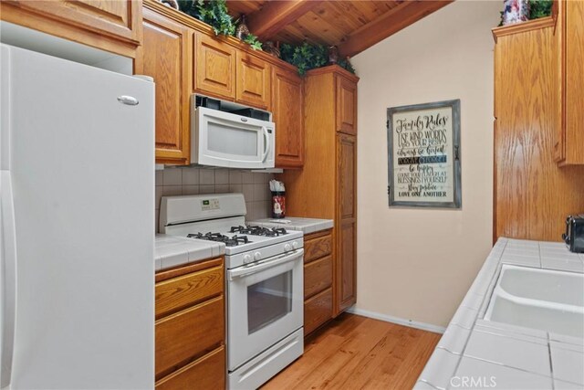 530 Bradbury Rd, Monrovia, CA 91016 - kitchen with white appliances, tile countertops, a wooden ceiling with exposed beams, tasteful backsplash, and light wood-type flooring