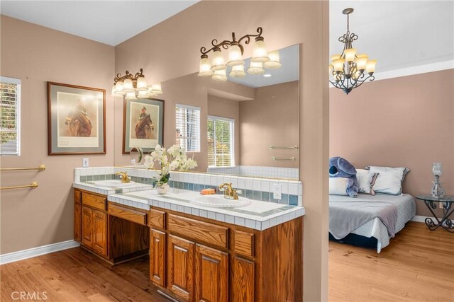 530 Bradbury Rd, Monrovia, CA 91016 - full bath featuring wood finished floors, double vanity, backsplash, and a chandelier