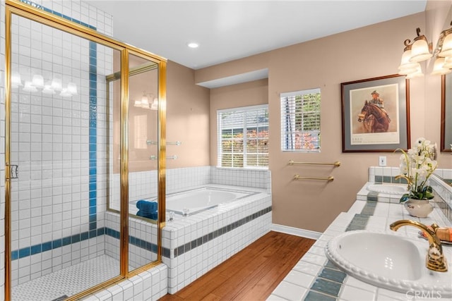 530 Bradbury Rd, Monrovia, CA 91016 - bathroom featuring wood finished floors, a bath, a stall shower, double vanity, and recessed lighting