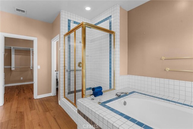 530 Bradbury Rd, Monrovia, CA 91016 - bathroom featuring a stall shower, a garden tub, a spacious closet, and wood finished floors