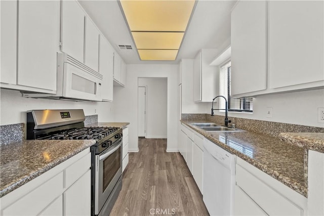 4706 Sepulveda Blvd, Sherman Oaks, CA 91403 - kitchen with white appliances, wood finished floors, white cabinetry, and dark stone countertops