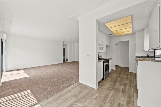 4706 Sepulveda Blvd, Sherman Oaks, CA 91403 - kitchen with gas stove, white microwave, white cabinetry, light wood-style floors, and open floor plan