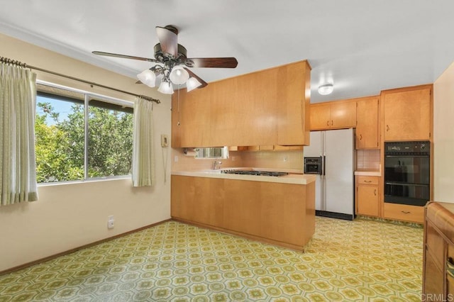 3448 Goldfinch St, San Diego, CA 92103 - kitchen with white fridge with ice dispenser, black oven, a peninsula, light countertops, and backsplash