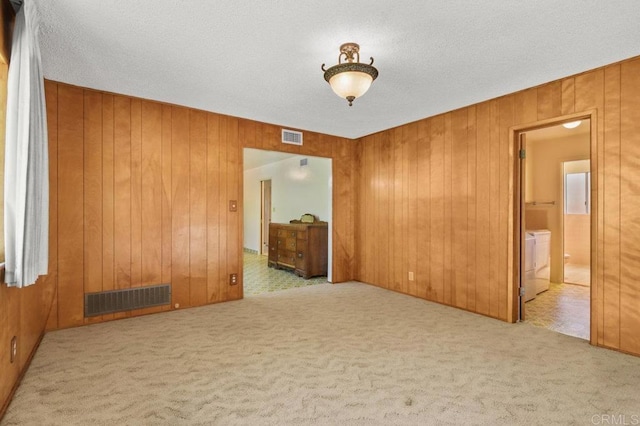 3448 Goldfinch St, San Diego, CA 92103 - carpeted empty room with wood walls, washer / clothes dryer, and a textured ceiling