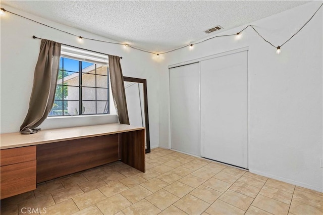 2021 Buckwheat Ave, Rosamond, CA 93560 - unfurnished bedroom with a textured ceiling, a closet, and an office area