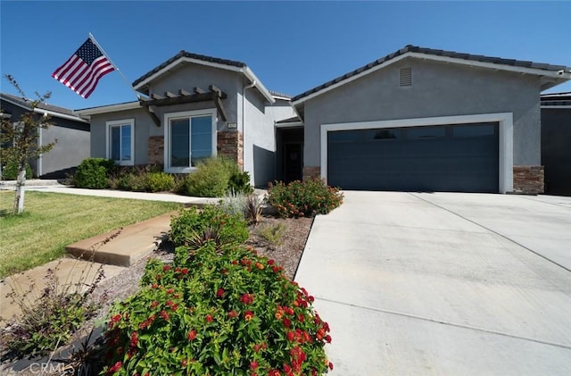 825 Spring St W, Madera, CA 93636 - ranch-style house with stone siding, stucco siding, an attached garage, driveway, and a front lawn