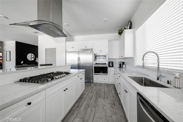 825 Spring St W, Madera, CA 93636 - kitchen with built in appliances, island exhaust hood, white cabinets, and light stone countertops