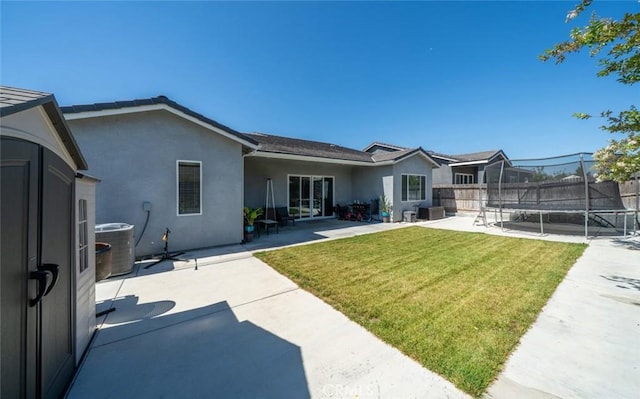 825 Spring St W, Madera, CA 93636 - rear view of property with a trampoline, stucco siding, and a patio