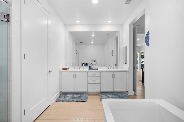 3100 Rivington, Irvine, CA 92612 - full bath featuring wood finished floors, double vanity, a freestanding tub, and recessed lighting