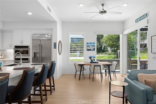 3100 Rivington, Irvine, CA 92612 - kitchen featuring appliances with stainless steel finishes, ceiling fan, white cabinets, light wood-style floors, and light countertops