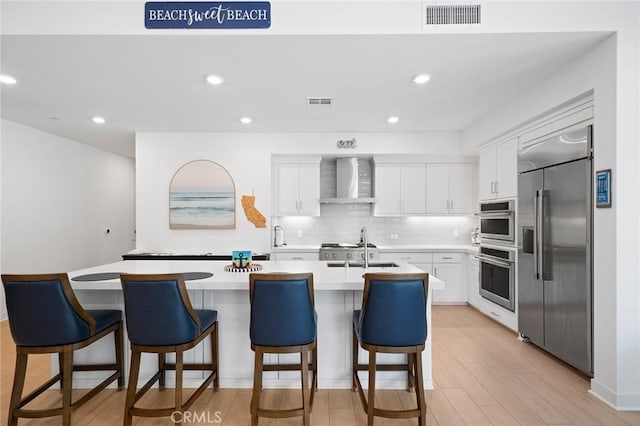 3100 Rivington, Irvine, CA 92612 - kitchen with stainless steel appliances, wall chimney range hood, white cabinetry, light countertops, and recessed lighting
