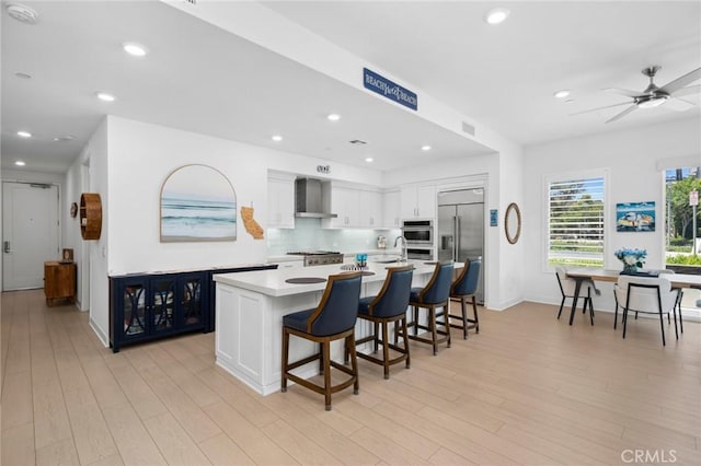 3100 Rivington, Irvine, CA 92612 - kitchen featuring appliances with stainless steel finishes, light countertops, wall chimney range hood, white cabinetry, and recessed lighting