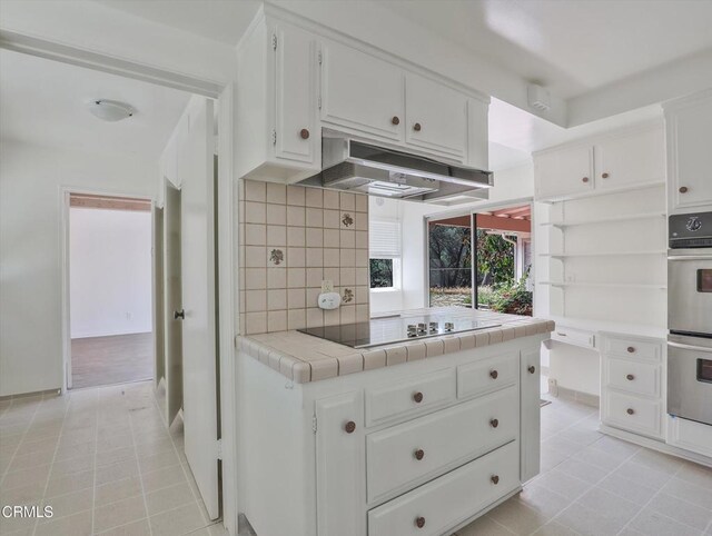 3914 Alta Vista Dr, La Canada Flintridge, CA 91011 - kitchen with black electric cooktop, under cabinet range hood, double oven, open shelves, and tile countertops