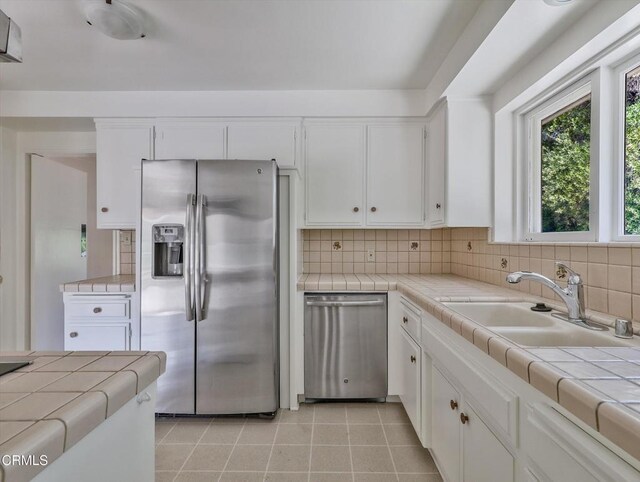 3914 Alta Vista Dr, La Canada Flintridge, CA 91011 - kitchen with stainless steel appliances, tile counters, white cabinetry, and backsplash
