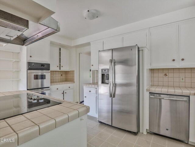 3914 Alta Vista Dr, La Canada Flintridge, CA 91011 - kitchen with appliances with stainless steel finishes, tile countertops, wall chimney range hood, and white cabinets