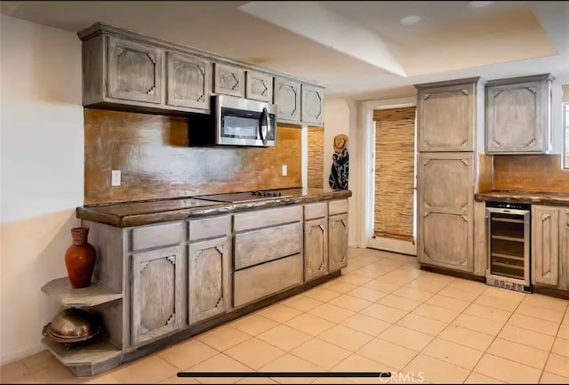 70138 Sullivan Rd Unit 29, Palms, CA 92277 - kitchen featuring beverage cooler, stainless steel microwave, dark countertops, backsplash, and light tile patterned flooring