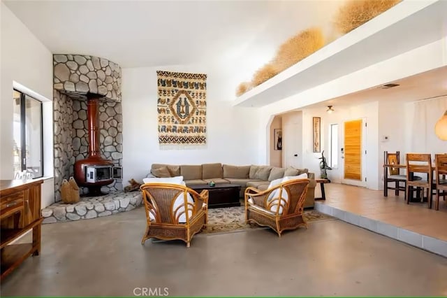 70138 Sullivan Rd Unit 29, Palms, CA 92277 - living room with finished concrete floors, a wood stove, and arched walkways