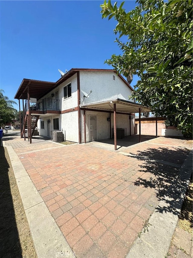 663 W 14th St, San Bernardino, CA 92405 - view of side of home featuring a patio, stairway, and stucco siding