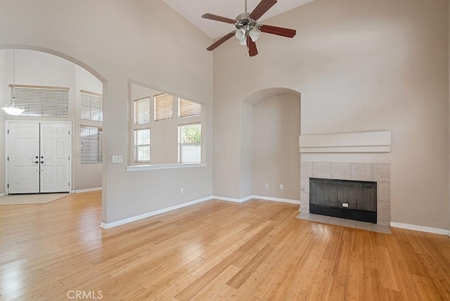 117 S Machala Pl, Rialto, CA 92376 - unfurnished living room with high vaulted ceiling, a ceiling fan, light wood-style floors, and a tiled fireplace
