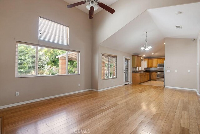 117 S Machala Pl, Rialto, CA 92376 - unfurnished living room with ceiling fan, a chandelier, light wood-style floors, and high vaulted ceiling