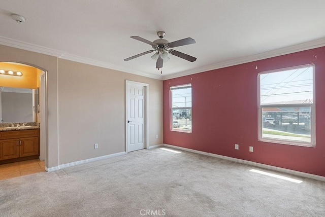 117 S Machala Pl, Rialto, CA 92376 - unfurnished bedroom featuring light carpet, arched walkways, ornamental molding, ensuite bathroom, and ceiling fan