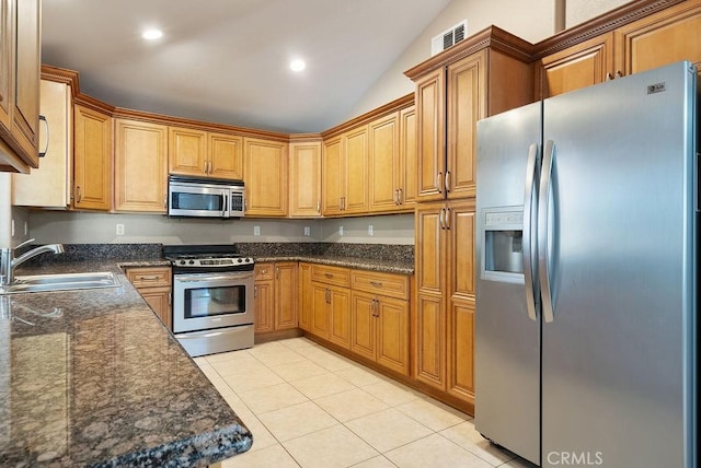 117 S Machala Pl, Rialto, CA 92376 - kitchen with appliances with stainless steel finishes, light tile patterned flooring, vaulted ceiling, recessed lighting, and brown cabinetry
