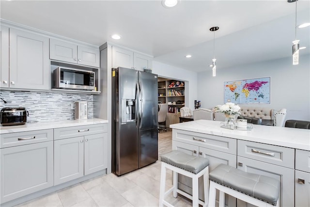456 W Huntington Dr Unit C, Arcadia, CA 91007 - kitchen featuring refrigerator with ice dispenser, stainless steel microwave, light countertops, a kitchen bar, and decorative light fixtures
