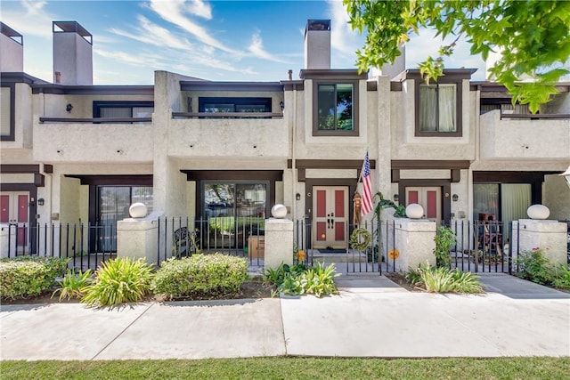456 W Huntington Dr Unit C, Arcadia, CA 91007 - view of property featuring a fenced front yard, a gate, a balcony, and stucco siding