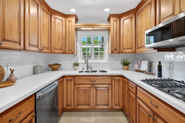 1303 E Monroe Ave, Orange, CA 92867 - kitchen featuring stainless steel appliances, brown cabinets, backsplash, light countertops, and recessed lighting