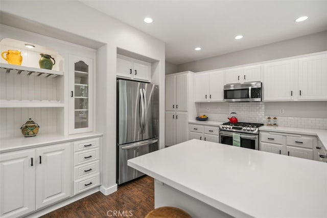 10 Cumberland Ln, Aliso Viejo, CA 92656 - kitchen with appliances with stainless steel finishes, dark wood-type flooring, white cabinetry, decorative backsplash, and recessed lighting