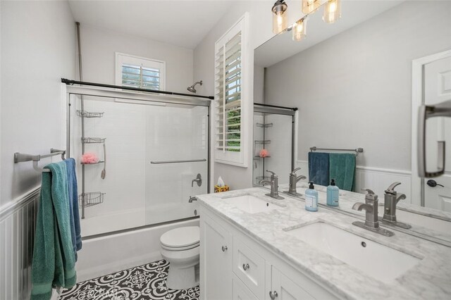 10 Cumberland Ln, Aliso Viejo, CA 92656 - bathroom featuring shower / bath combination with glass door, double vanity, a wainscoted wall, and tile patterned flooring