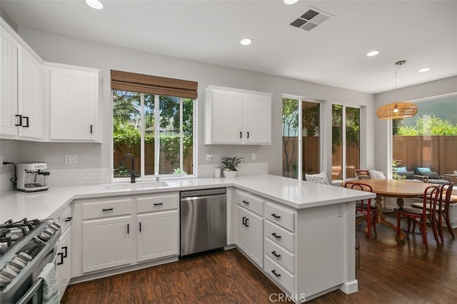 10 Cumberland Ln, Aliso Viejo, CA 92656 - kitchen with stainless steel appliances, a peninsula, recessed lighting, light countertops, and white cabinetry