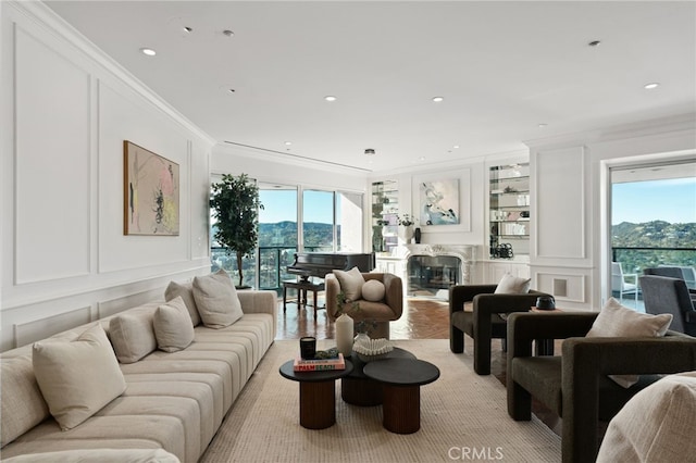 10490 Wilshire Blvd Unit 2704, Los Angeles, CA 90024 - living room featuring a decorative wall, ornamental molding, a high end fireplace, a mountain view, and recessed lighting
