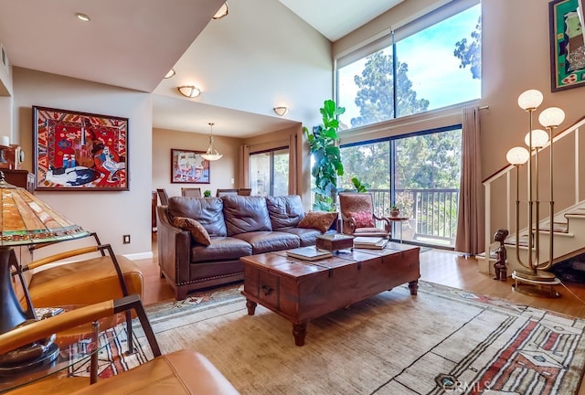 2015 E Broadway Unit 402, Long Beach, CA 90803 - living room with a towering ceiling, stairway, and wood finished floors