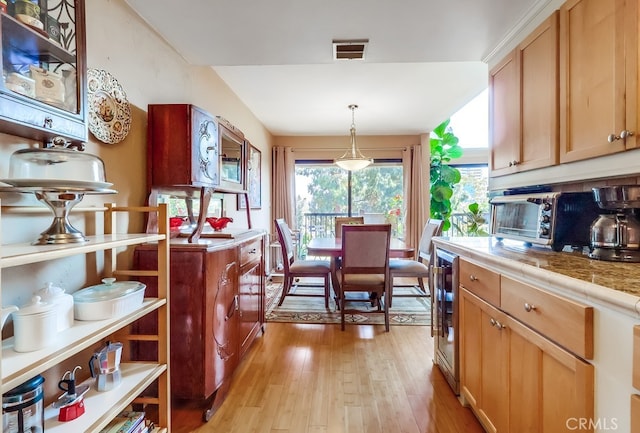 2015 E Broadway Unit 402, Long Beach, CA 90803 - kitchen with light wood-style flooring, wine cooler, and pendant lighting