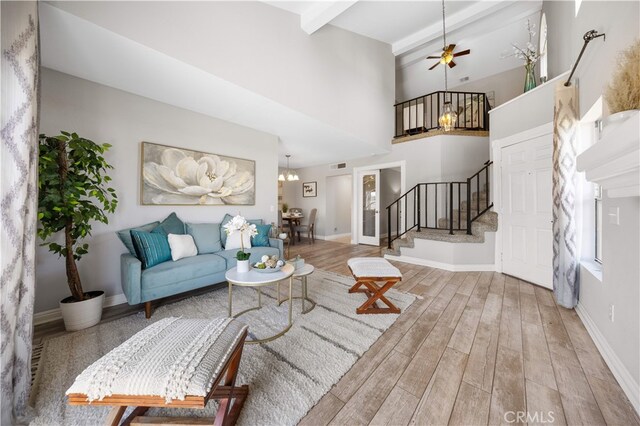 13199 Spire Cir, Chino Hills, CA 91709 - living area featuring stairs, wood finished floors, a high ceiling, a ceiling fan, and a chandelier
