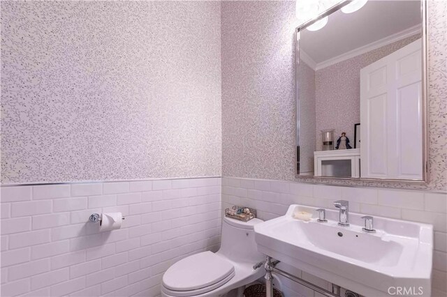 1525 Ramona Dr, Camarillo, CA 93010 - bathroom featuring wallpapered walls, ornamental molding, a wainscoted wall, and tile walls