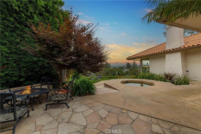 1525 Ramona Dr, Camarillo, CA 93010 - patio terrace at dusk with a fire pit, a patio area, and an in-ground hot tub