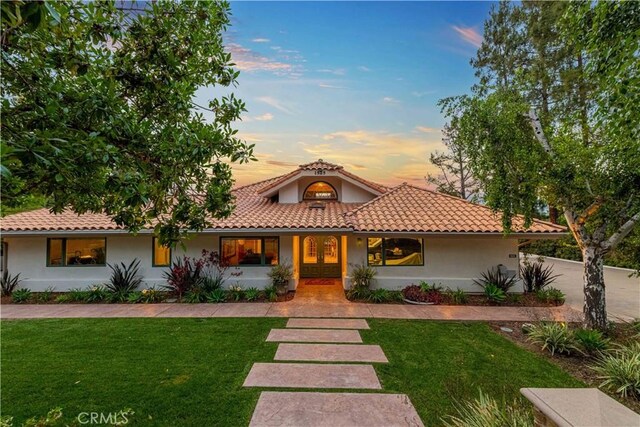 1525 Ramona Dr, Camarillo, CA 93010 - mediterranean / spanish home featuring stucco siding, a lawn, and a tile roof