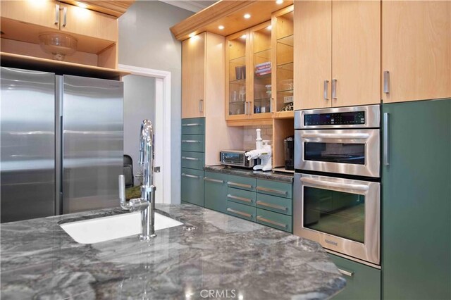 1525 Ramona Dr, Camarillo, CA 93010 - kitchen with appliances with stainless steel finishes, dark stone counters, glass insert cabinets, decorative backsplash, and recessed lighting