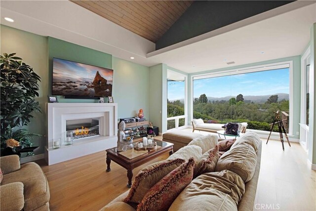 1525 Ramona Dr, Camarillo, CA 93010 - living area featuring lofted ceiling, wood finished floors, wood ceiling, a glass covered fireplace, and recessed lighting