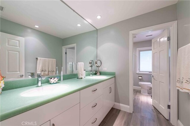 1525 Ramona Dr, Camarillo, CA 93010 - bathroom featuring double vanity, wood finished floors, and recessed lighting